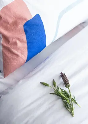a sock and a flower on a bed with a flag at Môss Suite - Monastiraki Square View in Athens
