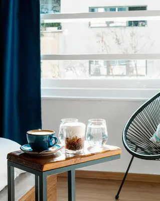 a table with a cup of coffee and a glass at Môss Suite - Monastiraki Square View in Athens