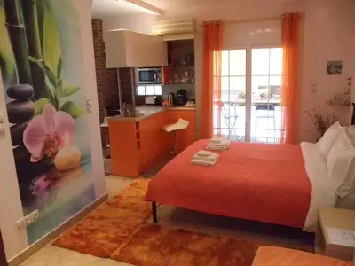 a bedroom with a red bed and a kitchen at Dreaming Stay in Athens