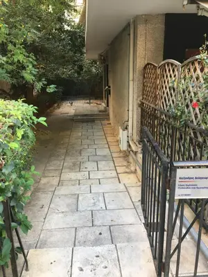 a stone walkway leading to a house with a gate at Dreaming Stay in Athens
