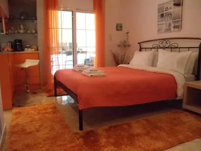 a bedroom with a bed with orange sheets and a orange blanket at Dreaming Stay in Athens