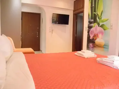 a bedroom with a bed with orange sheets and towels at Dreaming Stay in Athens