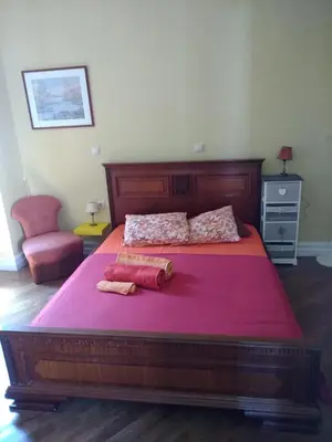 a bedroom with a large wooden bed with red sheets at Acropolis Apartment in Athens