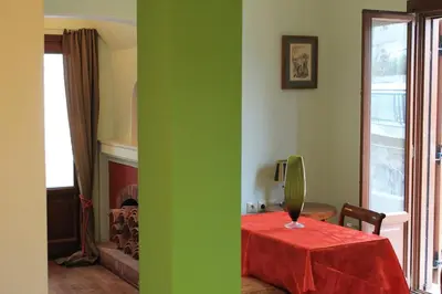 a green room with a table with a vase on it at Acropolis Apartment in Athens