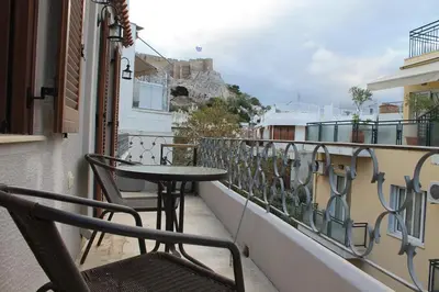 a balcony with a table and chairs on a building at Acropolis Apartment in Athens