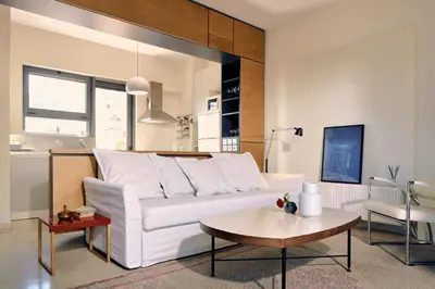 a living room with a white couch and a table at Two level apartment with panoramic view in Athens