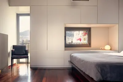 a bedroom with a bed and a chair and a window at Two level apartment with panoramic view in Athens
