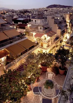 a view of a city at night with a table and chairs at Two level apartment with panoramic view in Athens