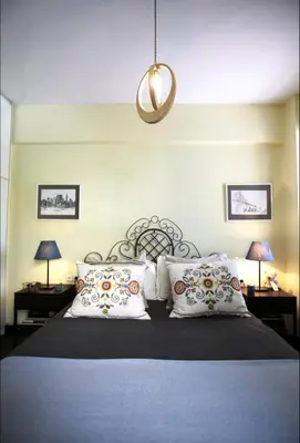 a bedroom with a bed with two tables and two lamps at Mets Area, Hip, Tasteful & Ultra Convenient Studio for 2 in Athens