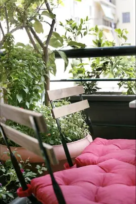 a bed on a balcony next to a potted plant at Mets Area, Hip, Tasteful & Ultra Convenient Studio for 2 in Athens