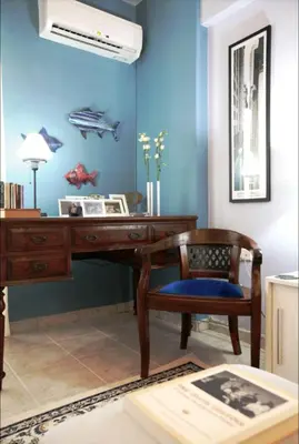 a desk and a chair in a room with a blue wall at Mets Area, Hip, Tasteful & Ultra Convenient Studio for 2 in Athens