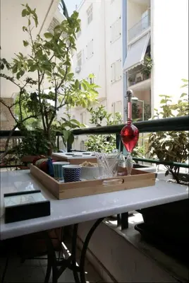 a glass of wine sitting on a table on a balcony at Mets Area, Hip, Tasteful & Ultra Convenient Studio for 2 in Athens