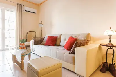 a living room with a couch and a glass table at Athens Casa Bonita in Athens