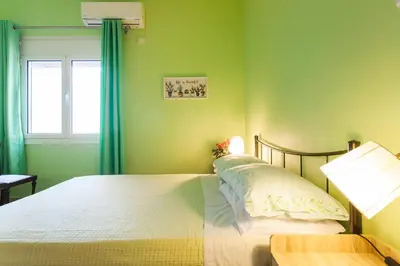 a green bedroom with a bed and a window at Athens Casa Bonita in Athens