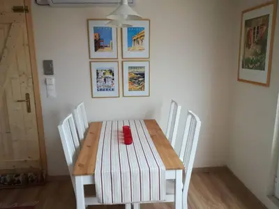 a dining room table with white chairs and a wooden table with a red bowl on at LITTLE HOUSE ON THE ROOFTOP in Athens