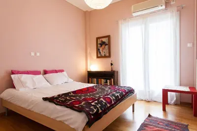 a bedroom with a large bed and a window at 2 Bedroom Artist's Apartment - So Athens in Athens