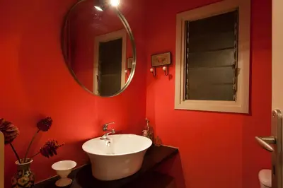 a red bathroom with a sink and a mirror at 2 Bedroom Artist's Apartment - So Athens in Athens