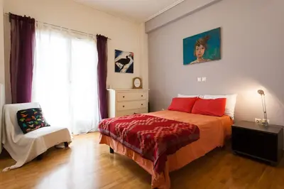 a bedroom with a bed and a chair and a window at 2 Bedroom Artist's Apartment - So Athens in Athens