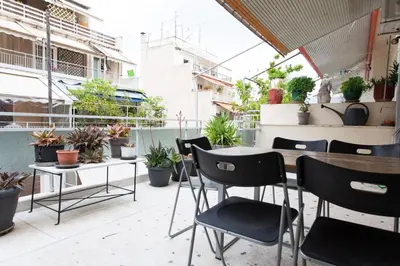 a patio with tables and chairs and potted plants at 2 Bedroom Artist's Apartment - So Athens in Athens