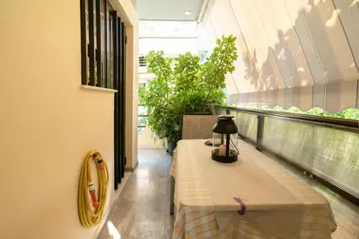a balcony with a table and plants in a building at Golden Aurora - Modern Apartment in Egaleo-Athens in Athens