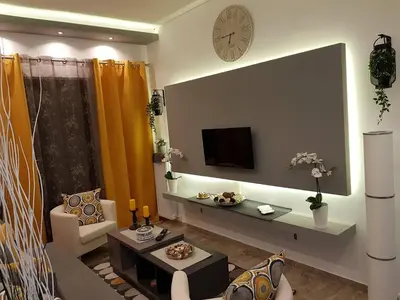 a living room with a couch and a tv on a wall at Golden Aurora - Modern Apartment in Egaleo-Athens in Athens