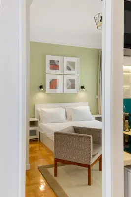 a small bedroom with a bed and a chair at Dinostratus House - Boutique Studios in Athens
