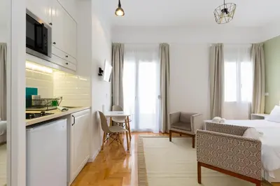 a hotel room with a kitchen and a bed and a table at Dinostratus House - Boutique Studios in Athens
