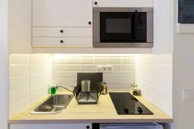 a kitchen with a sink and a microwave at Dinostratus House - Boutique Studios in Athens
