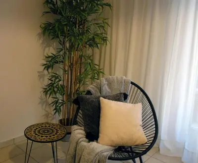 a chair with a pillow and a plant in a room at Acropolis, Urban Lifestyle apartment in Athens