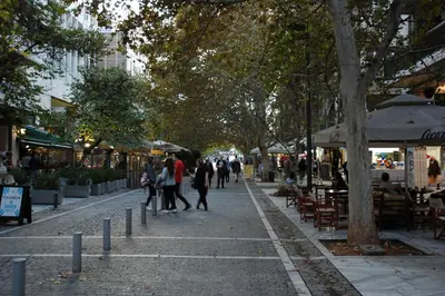 a group of people walking down a street with trees at Acropolis, Urban Lifestyle apartment in Athens