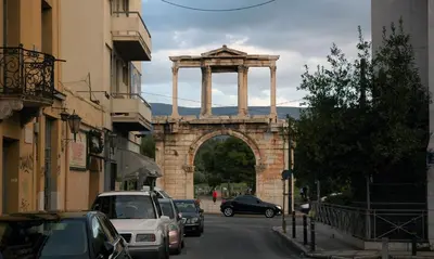 a building with an arch in the middle of a street at Acropolis, Urban Lifestyle apartment in Athens