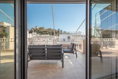 a balcony with a table and chairs and windows at Acropolis View in Athens