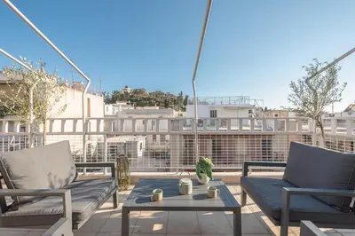 a patio with two chairs and a table on a balcony at Acropolis View in Athens