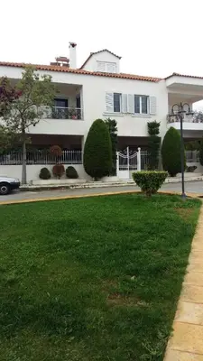 a white house with a green lawn in front of it at NN Luxury Room near Athens Airport in Spáta
