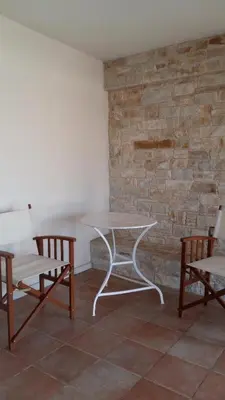 a table and two chairs sitting next to a stone wall at NN Luxury Room near Athens Airport in Spáta