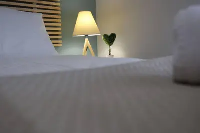 a bedroom with a white bed with a lamp and a plant at Penthouse lux flat with 2 bd next to larissis in Athens