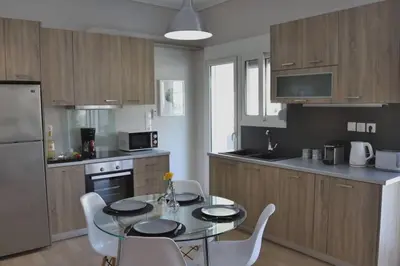 a kitchen with a table and chairs in a kitchen at Penthouse lux flat with 2 bd next to larissis in Athens