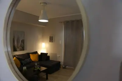 a living room with a couch and a mirror at Penthouse lux flat with 2 bd next to larissis in Athens