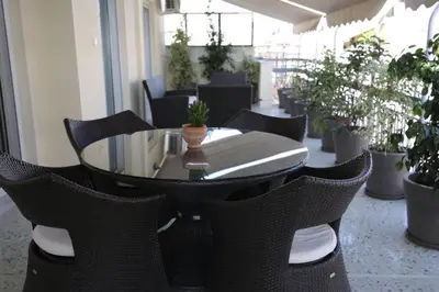 a table and chairs in a room with potted plants at Penthouse lux flat with 2 bd next to larissis in Athens