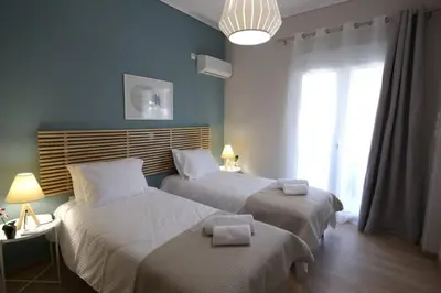 two beds in a bedroom with blue walls at Penthouse lux flat with 2 bd next to larissis in Athens