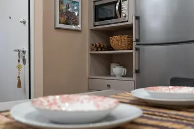 a table with two white plates and a refrigerator at Absolute Athens v in Athens