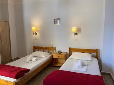 two beds in a hotel room with two towels at Hotel Ionion in Piraeus