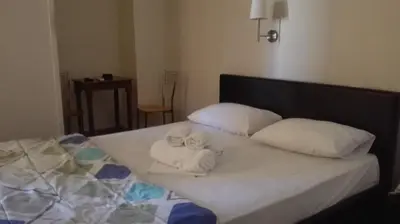 two dolls are sitting on a bed with pillows at Hotel Ionion in Piraeus