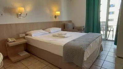 a bedroom with a bed with two towels on it at Hotel Ionion in Piraeus