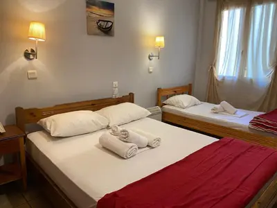 two beds in a room with towels on them at Hotel Ionion in Piraeus