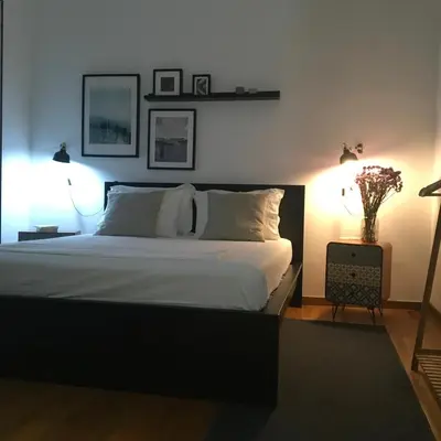 a bedroom with a large bed with two lights on it at Evelina’s apartment in Athens