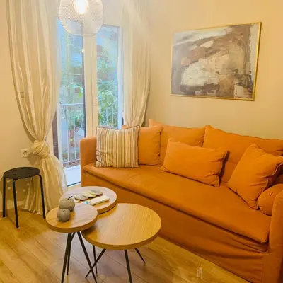 a living room with a orange couch and a table at Bring only your toothbrush! in Athens