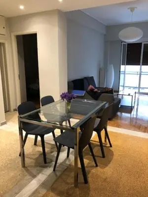 a glass table and chairs in a living room at Kleopatra Apartment in Acropolis in Athens