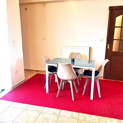 a dining room with a table and chairs on a red rug at Horizon apartment Athens near to Acropolis, sea & subway in Athens