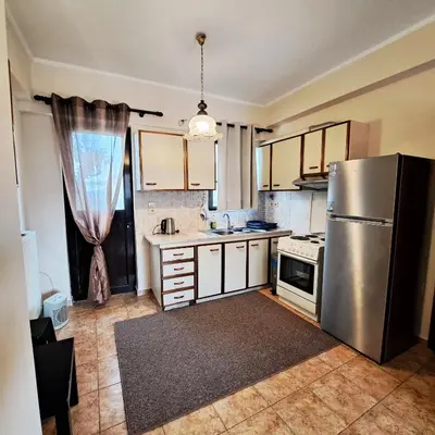 a kitchen with a stainless steel refrigerator and a window at Horizon apartment Athens near to Acropolis, sea & subway in Athens